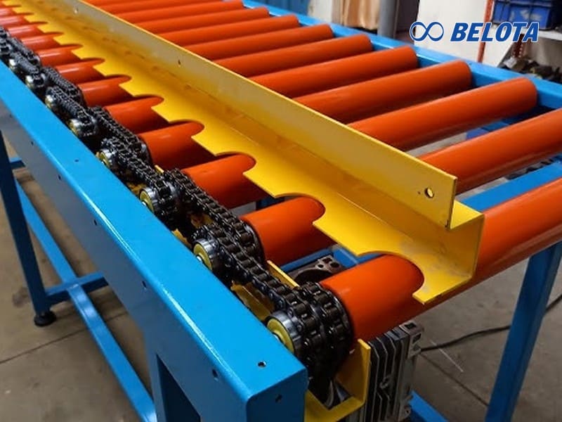 Băng tải con lăn xích hoạt động dựa trên cơ chế xích truyền động kết hợp với bánh răng