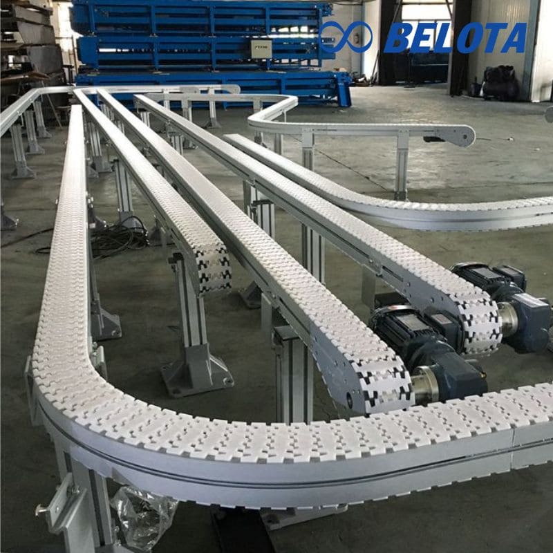 Băng tải xích nhựa chạy cong là hệ thống cho phép vận chuyển hàng hóa linh hoạt theo các góc cua và đường cong trong nhà máy