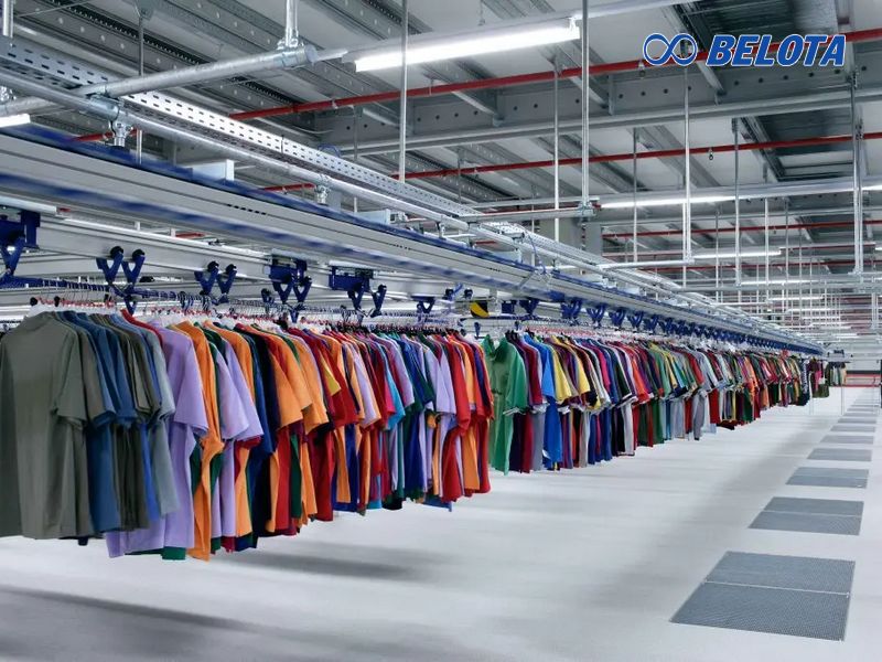 Băng tải xích treo dây chuyền may mặc là hệ thống vận chuyển tự động, sử dụng xích và móc treo để di chuyển sản phẩm liên tục trên ray treo trên cao