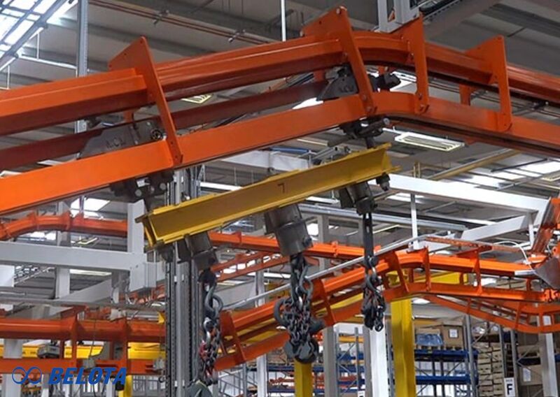 Băng tải xích treo sử dụng cơ cấu xích treo trên cao để di chuyển hàng hóa trong không gian ba chiều