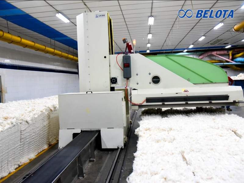 Băng tải máy xé kiện bông đặt nằm dọc theo đường ray di chuyển của máy xé kiện tự động