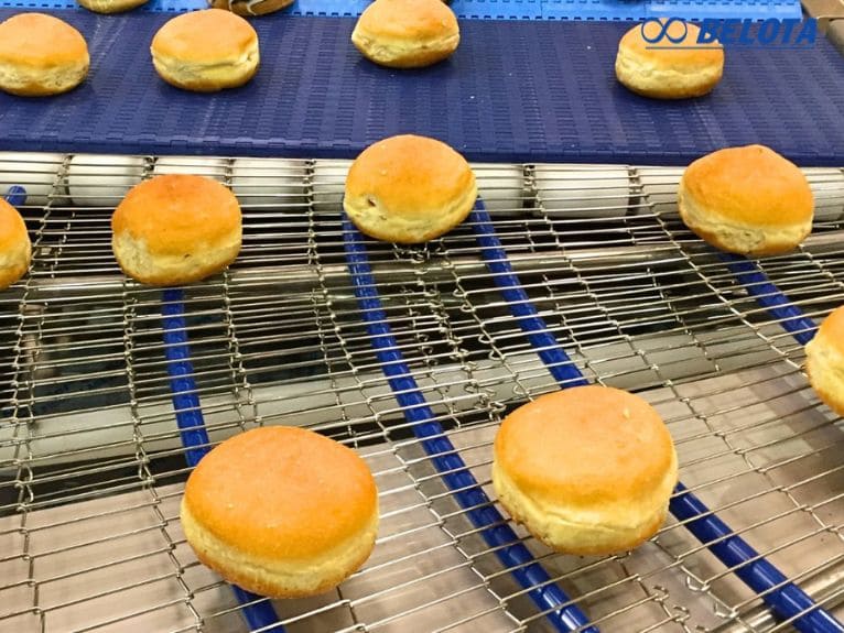 Khuôn bánh được đưa vào lò nướng bằng băng tải lưới inox chịu nhiệt