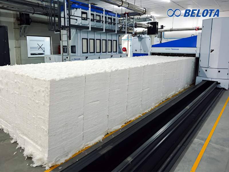 Máy hút bông hoạt động bằng cách hút bông từ các kiện được xếp dọc hai bên và đưa vào hệ thống trộn